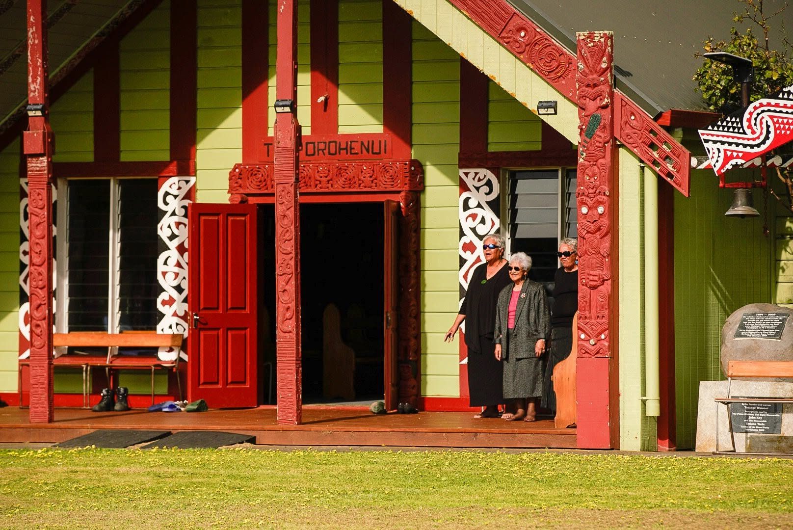 Whānau gathered and smiling outside the marae