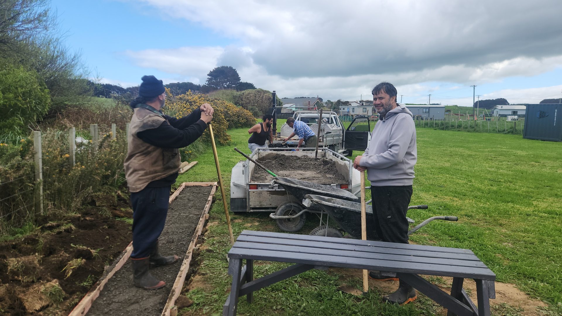 A group of adults working together on the marae gardens.