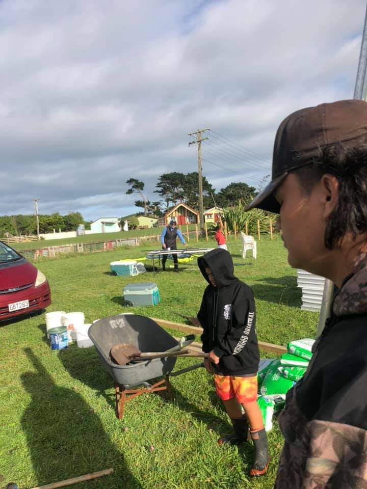 Whānau and tamariki together outdoors at the marae